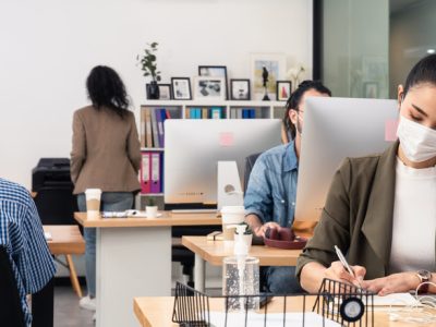 Group of Asian team business people working in office with new normal social distancing lifestyle concept. Man and woman wear protective face mask and keep distancing to prevent COVID virus in company